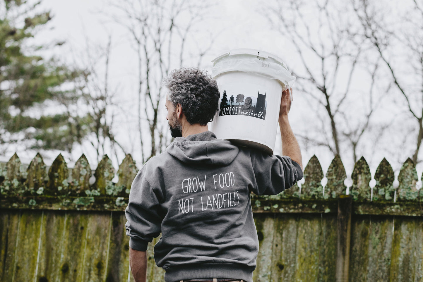 compost nashville worker carrying a bucket of compost on shoulder